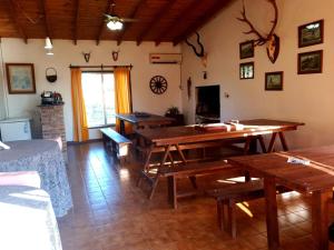 sala de estar con mesas de madera y chimenea en Hostal Naico, en Naicó