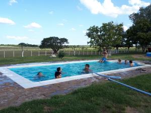 un grupo de personas nadando en una piscina en Hostal Naico, en Naicó