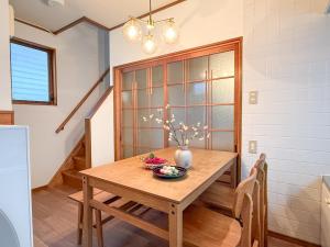 Una mesa de comedor con un jarrón de flores encima. en 春花秋月 -Shunkashugetsu-, en Kawasaki 17 fotos más