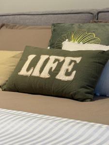 a bed with a green pillow with the word life on it at Oasis Bay Lalzi in Lalzit Bay