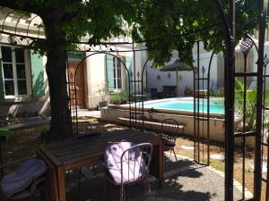 a patio with a table and chairs next to a pool at Studio indépendant dans charmante bastide in Mallemort