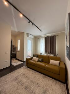 a living room with a brown couch and a kitchen at Oasis Bay Lalzi in Lalzit Bay