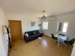 ein Wohnzimmer mit Sofa und Tisch in der Unterkunft Cottage Abrunheiro Grande in Vila de Rei