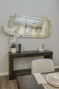 a mirror on a wall above a table with a chair at Modern Family Home Sleeps 8 in Dallas