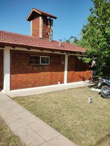 a brick house with a motorcycle parked in front of it at Pao Pei in Santa Rosa de Calamuchita