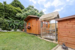a small wooden building with a cage in a yard at Relaxing 3-Bedroom Retreat House Free Parking 8ppl in Ollerton