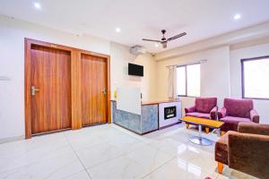 a living room with two chairs and a table at Collection O LIG Main Road Indore in Indore