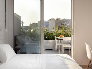 a bedroom with a bed and a balcony with a table at Athens View Loft - 02 in Athens