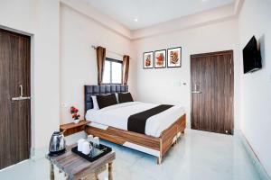 a bedroom with a bed and a table in it at Hotel O Prayag Central Railway Junction in Prayagraj