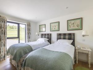 two beds in a room with a window at Phils House in Lairg +11 photos