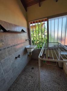 a bathroom with a bed and a sink and a window at Departamentos Mary Federacion in Federación