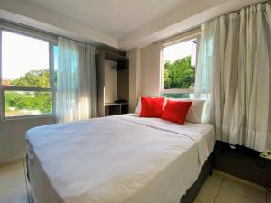 ジョアンペソアにあるJoao Pessoa Cabo Branco - Flat Vista Mar- 418- Green Sunset com piscina frente marのベッドルーム1室(白い大型ベッド1台、赤い枕2つ付) +26枚の写真