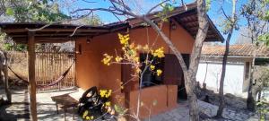 ein Haus mit Zaun und einem Baum in der Unterkunft Chalés Santo Verde 2 in Goiás + 2 Fotos