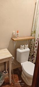 a bathroom with a toilet and a wooden shelf on the wall at J home stay in Maluk