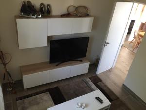 una sala de estar con TV en un armario blanco en Villa Castel Rocchero, en Castel Rocchero