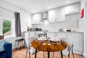 a kitchen with a table with wine glasses on it at Comfortable 2 Bed Apt, Sleeps 8, Parking, Great for Contractors, Families and Leisure Stays, West Midlands, near Birmingham, Edenwood Residence in Droitwich +55 photos