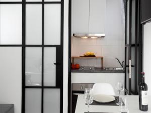 雅典的住宿－雅典景閣樓公寓- 02，厨房配有桌子和两把椅子,设有窗户。