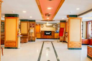 a lobby with orange and yellow walls and a tile floor at Townhouse Oak Jaipur Arya Square Shopping Mall in Jaipur