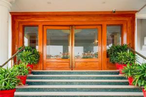 a wooden door on a building with stairs at Townhouse Oak Jaipur Arya Square Shopping Mall in Jaipur
