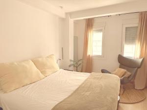 a bedroom with a bed and a chair and a window at Ola A Coruña in A Coruña