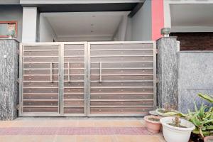 a gate in front of a house with plants at Hotel O Sector 20 Noida in Noida