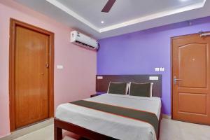 a bedroom with a large bed with purple walls at Collection O Tirupati Bus Terminal in Tirupati