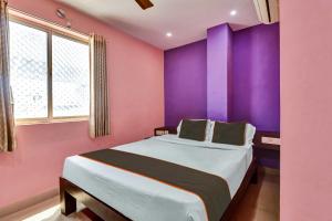 a bedroom with a large bed with purple walls at Collection O Tirupati Bus Terminal in Tirupati