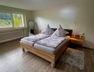 a bedroom with a bed with pillows and a window at Whirlpool, Billiard, Sauna! Ferienhaus Lacher in Baiersbronn