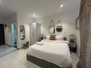 a large white bedroom with a large bed and mirrors at APARTMENTS GH - Accra - Cantonments - Embassy Gardens in Accra +64 photos