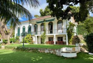 una grande casa bianca con una palma di Casa Aprazível 5 a Rio de Janeiro