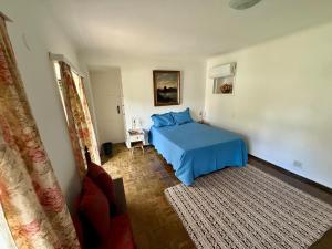 una camera con un letto blu e un tappeto di Casa Aprazível 5 a Rio de Janeiro Altre 59 foto