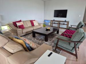 a living room with a couch and a table at Modern Luxury Beach Villa in Ballito
