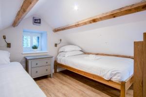 una camera da letto con due letti e una finestra di The Old Smithy - 2 Bedroom Cottage - Reynoldston a Reynoldston
