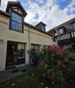 an exterior view of a house with pink flowers at Agnes Little Corner in Honfleur