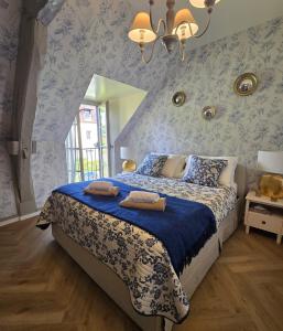 a bedroom with a bed with blue and white wallpaper at Agnes Little Corner in Honfleur