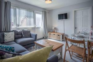 a living room with a couch and a table at Langcliffe Park - 2 Bedroom Chalet - Mumbles in The Mumbles
