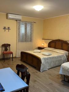 une chambre avec un lit, une table et des chaises dans l'établissement Casa di Genni, à Reggio de Calabre