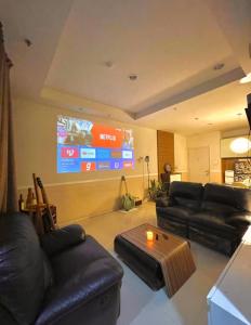 Μια τηλεόραση ή/και κέντρο ψυχαγωγίας στο Cozy 3BR Suite Apartment with Projector, Pool, Netflix, Board games, Dart
