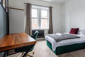 ウォールセンドにある2 Br Home Perfect For Short And Long Term Stayのベッドと机と窓のある寝室