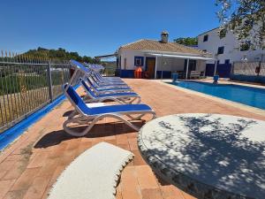 three lounge chairs sitting next to a swimming pool at Casa rural Bodega Dorada in Cehegín