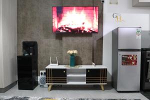 a tv hanging on a wall with a fireplace at Gray Havens Homes in Rungiri