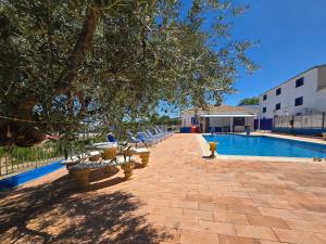 a pool with tables and chairs next to a building at Casa rural Bodega Dorada in Cehegín