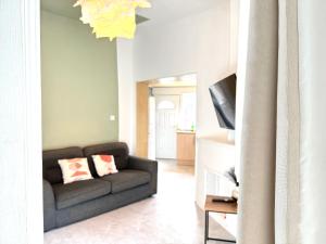 a living room with a couch and a television at Bee Stays - Cooper House in Haydock +15 photos