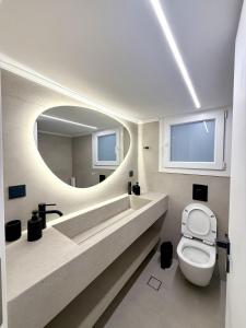 a bathroom with a toilet and a large mirror at Acropolis Path - Elegant Apartment near Plaka in Athens +23 photos