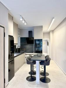a kitchen with a table and chairs in a room at Acropolis Path - Elegant Apartment near Plaka in Athens