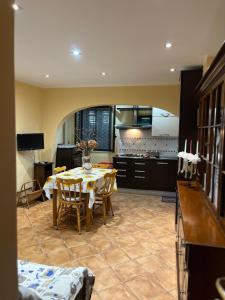 une salle à manger avec une table et une cuisine dans l'établissement Casa di Genni, à Reggio de Calabre