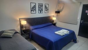 a bedroom with a blue bed and two lamps at Hotel El Paraiso Boutique in Villa Carlos Paz +150 photos