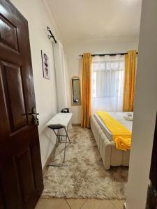 By the Coastals في مومباسا: غرفة نوم بها سرير وطاولة ونافذة