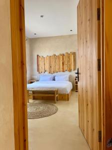 a bedroom with a large bed and a wooden wall at SURFHALLA Morocco in Imsouane