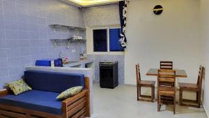 a living room with a blue couch in a kitchen at AMIVI Plaza ADIDOADIN in Lomé